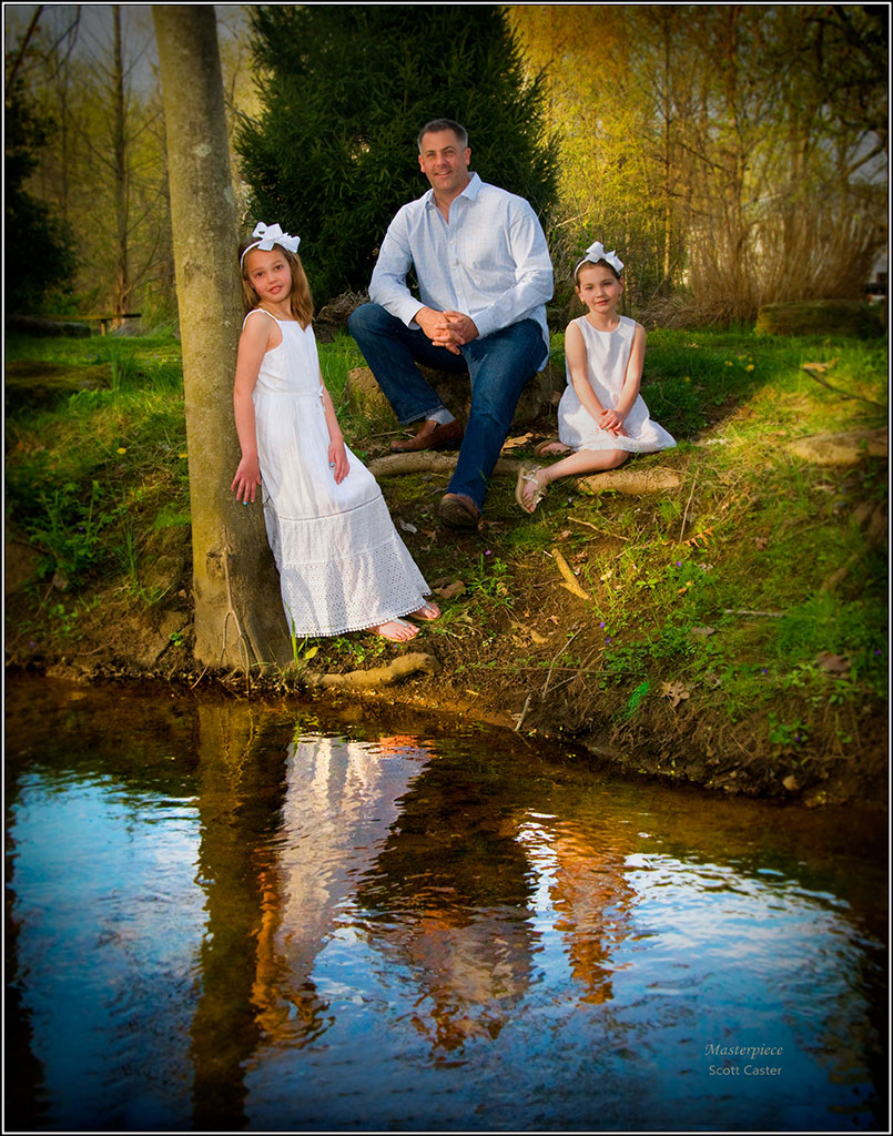 Family Portrait by the water. Father and two daughters.